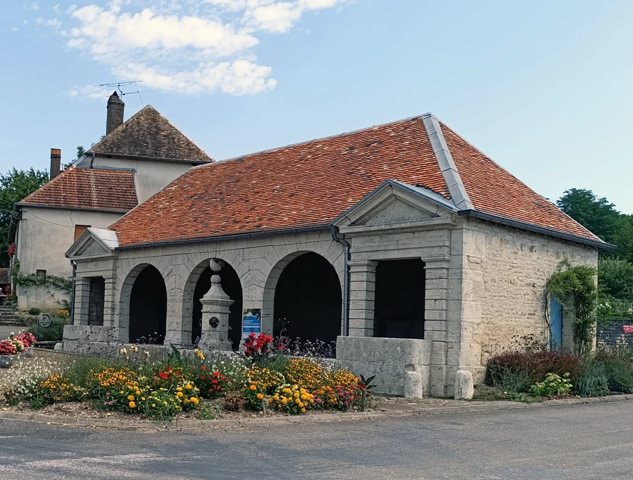 Lavoir public traditionnel français avec architecture en pierre calcaire et arcades voûtées