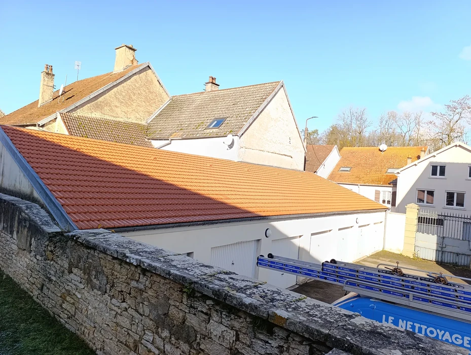 Chantier de rénovation de toiture en extérieur avec ouvrier sur toit d'habitation