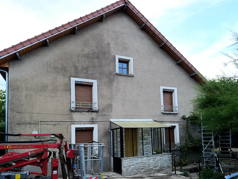 Scène extérieure montrant un mur de soutènement en pierres naturelles présentant des signes de détérioration et d'infiltration d'eau