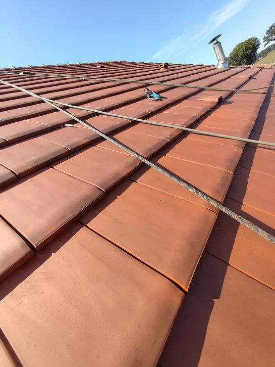 Nettoyage ext&eacute;rieur d'une terrasse en pierre par une personne &eacute;quip&eacute;e de gants de protection jaunes utilisant une brosse de r&eacute;curage &agrave; poils durs