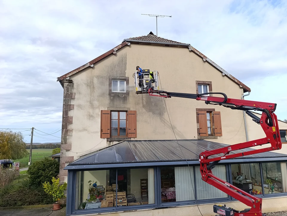 Homme en salopette effectuant des travaux de maintenance sur un volet roulant extérieur sous pergola