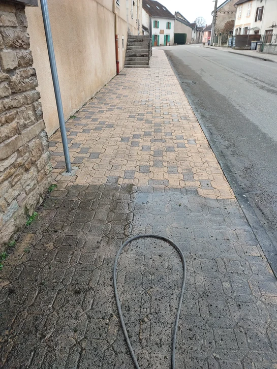 Paysage côtier méditerranéen avec eaux turquoise cristallines, formation rocheuse calcaire émergée, végétation de maquis sur falaises, montagnes en arrière-plan